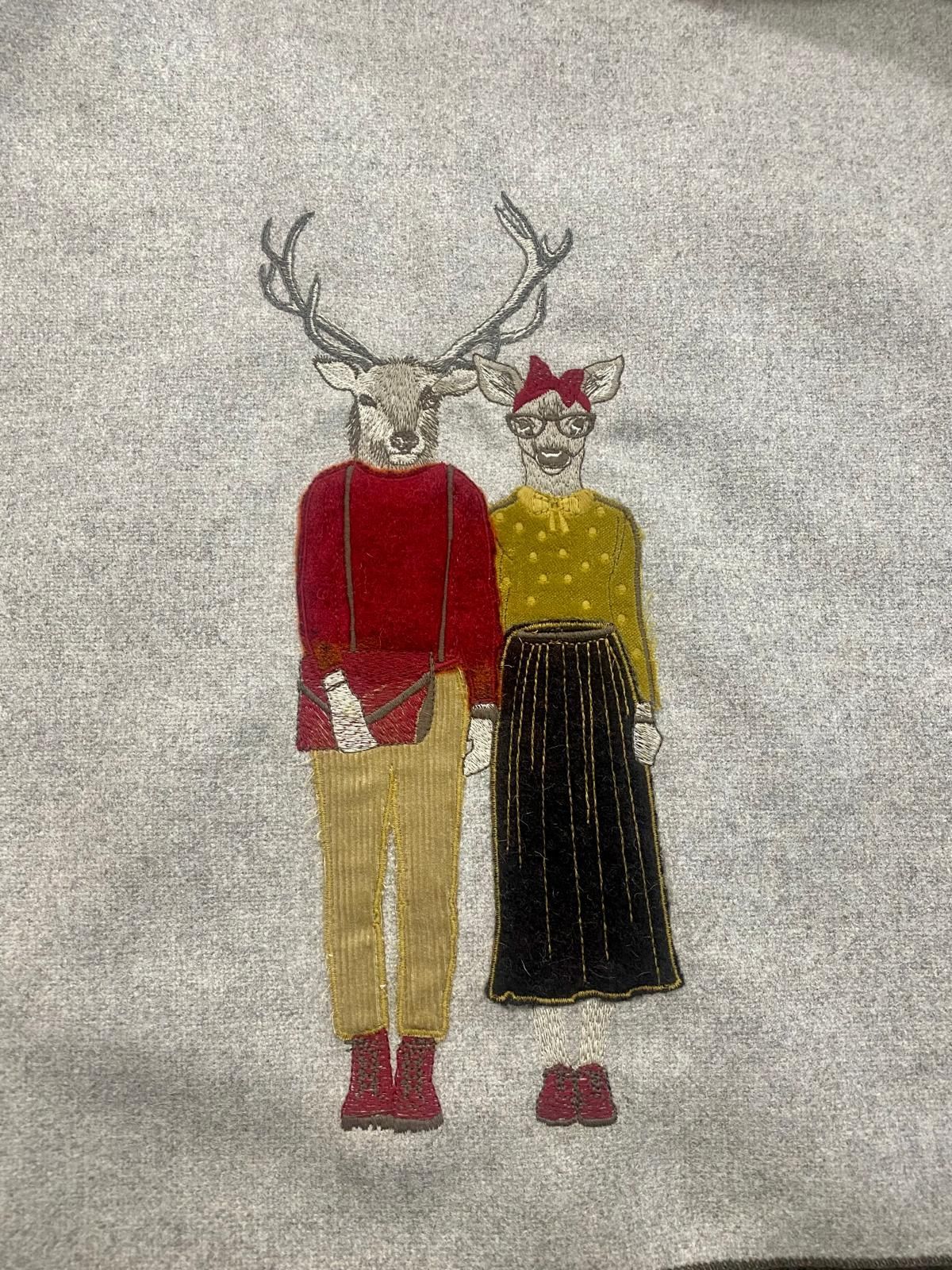 Un uomo e una donna con teste di cervo sono in piedi uno accanto all'altro.