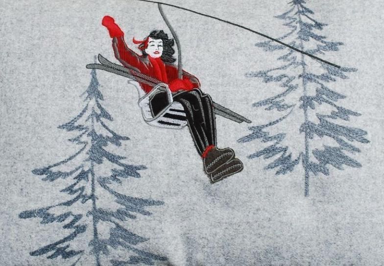 Una donna sta salendo su uno skilift con alberi sullo sfondo