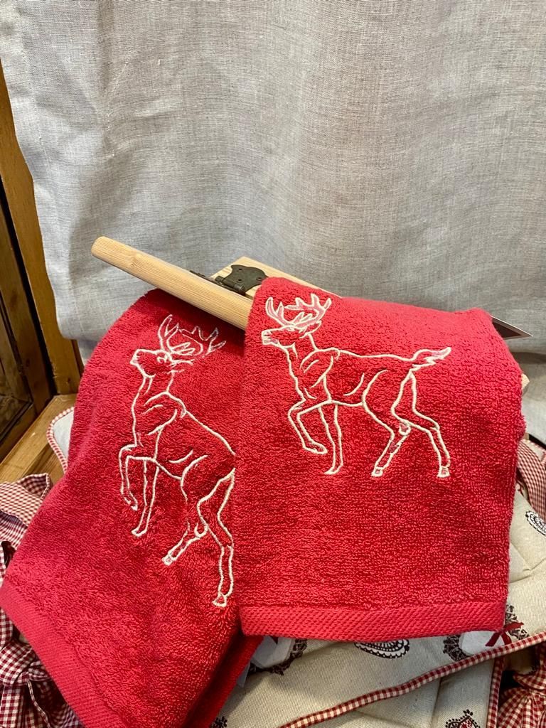 Un paio di asciugamani rossi con delle renne ricamate.