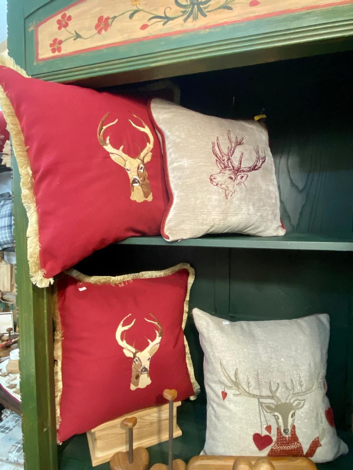 Cuscini rossi e bianchi con dei cervi sopra sono su uno scaffale