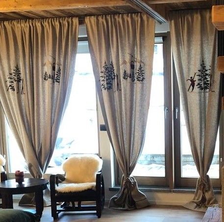 Un soggiorno con tante tende e una sedia