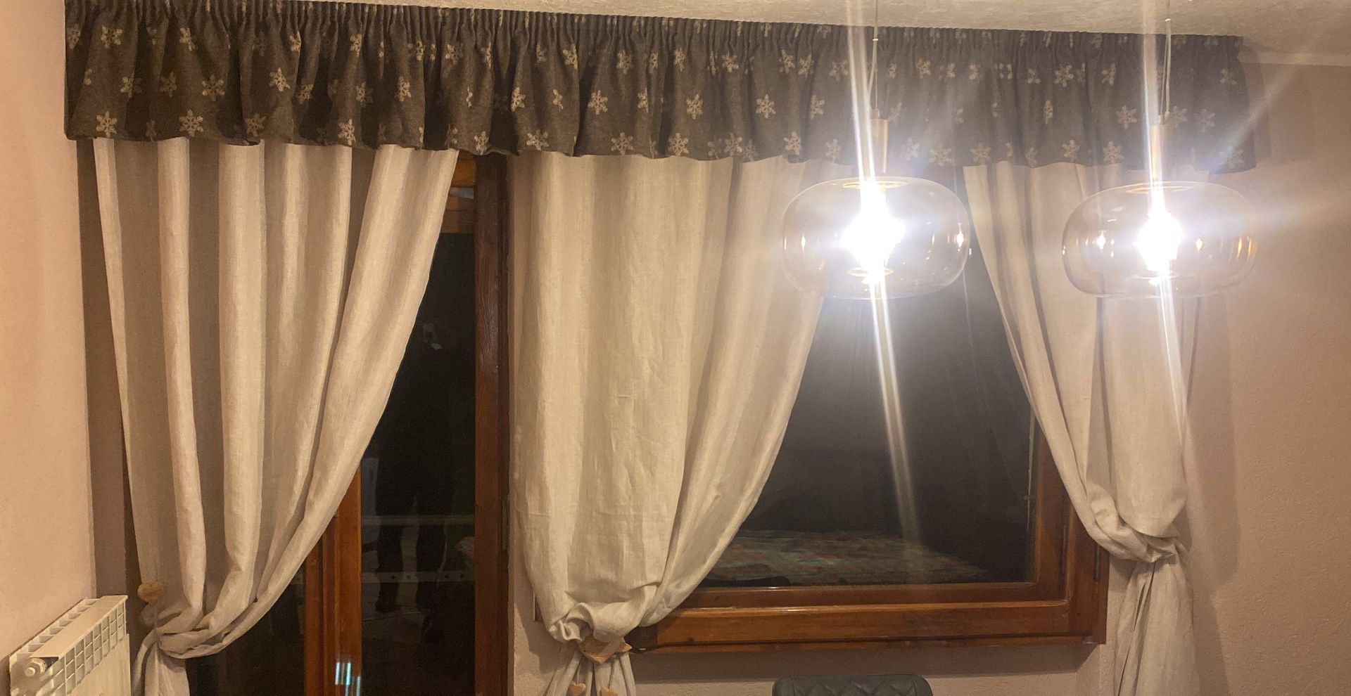 Un paio di tende sono appese a una finestra in una stanza.