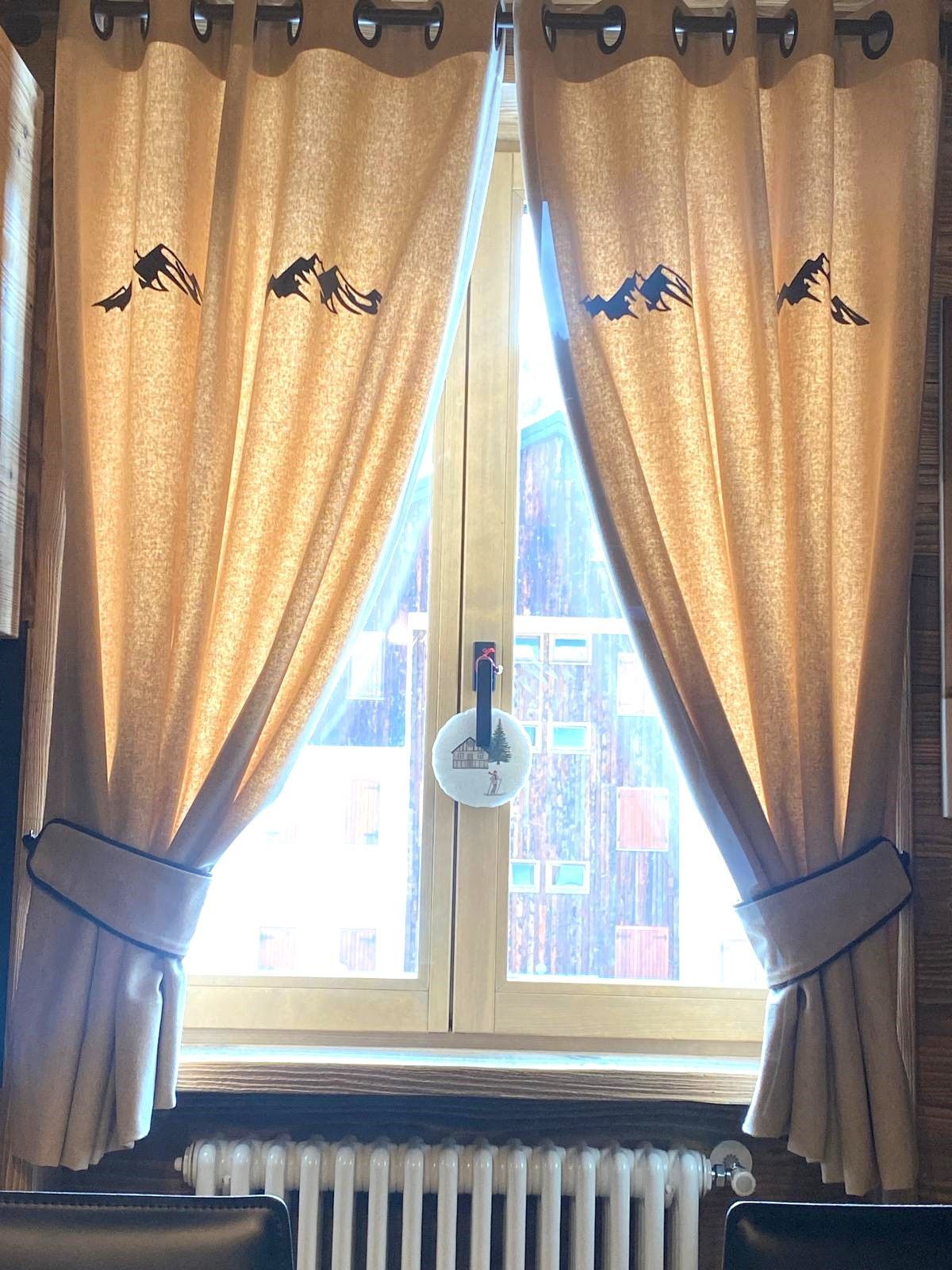 Una finestra con tende e un termosifone in una stanza