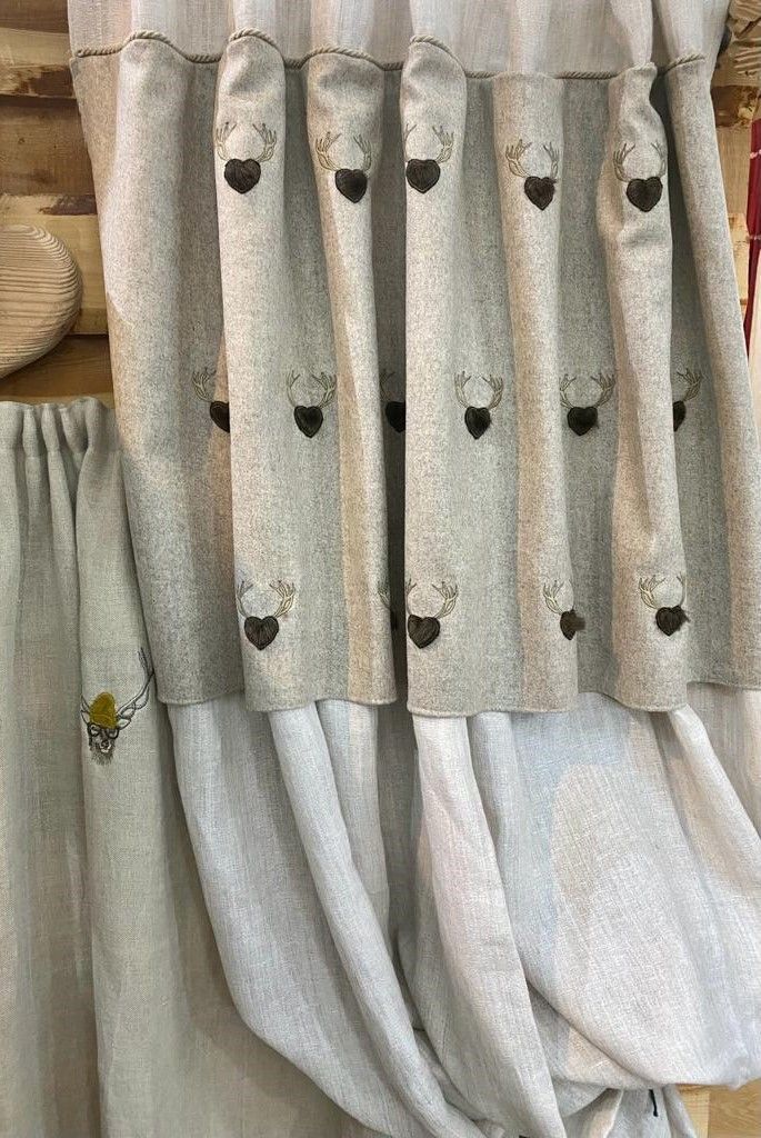Un primo piano di un paio di tende con delle pecore ricamate.