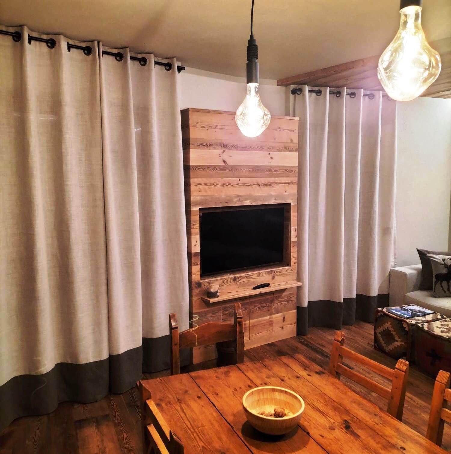 Un soggiorno con una tv montata a parete in legno