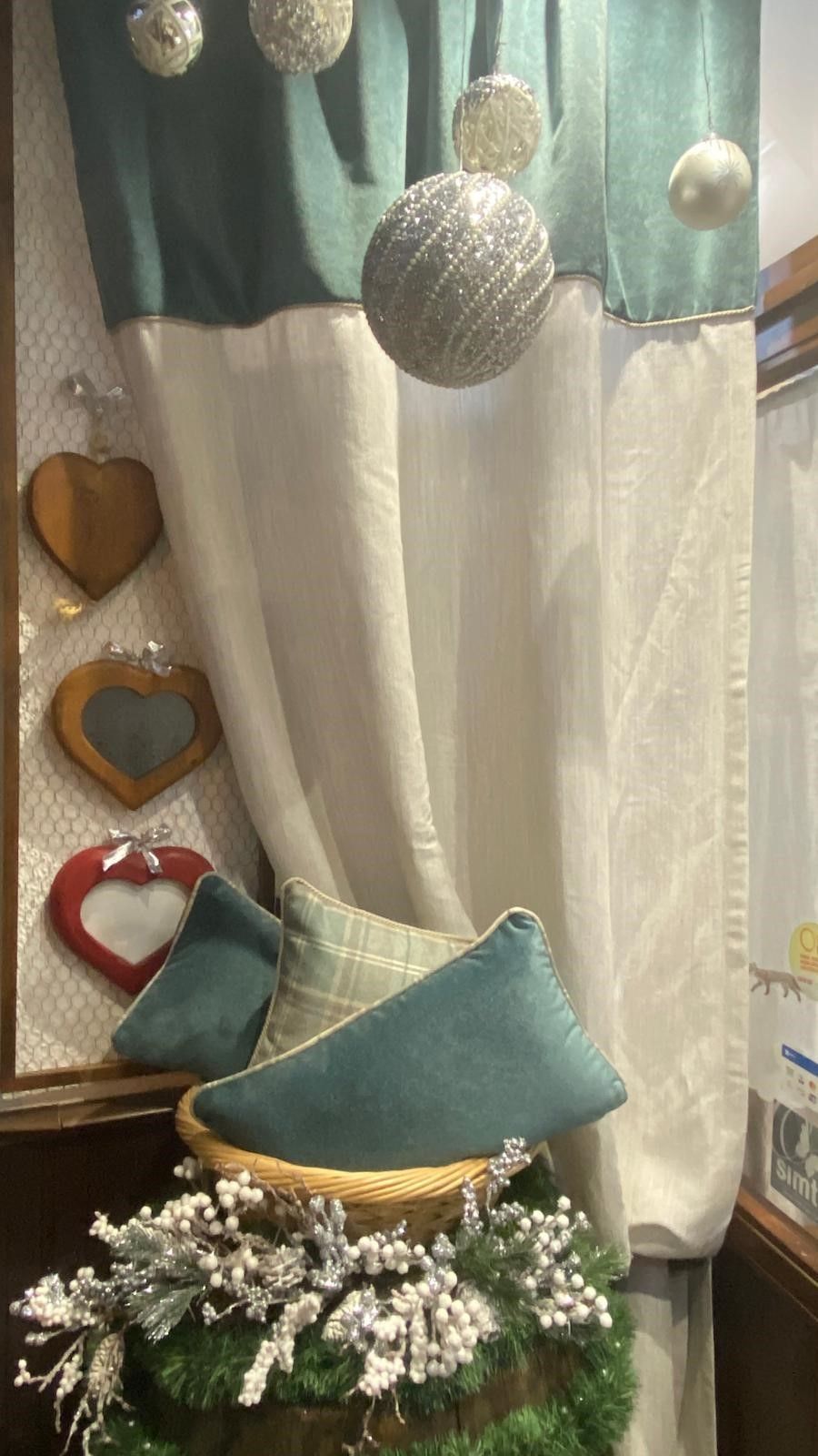 Una vetrina con decorazioni natalizie e cuscini.