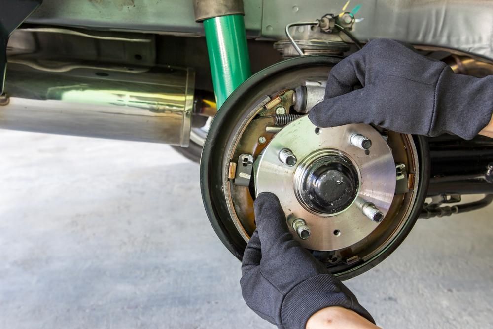 A Person is Fixing the Brake on a Car — Wollongong Auto Excellence In Wollongong, NSW