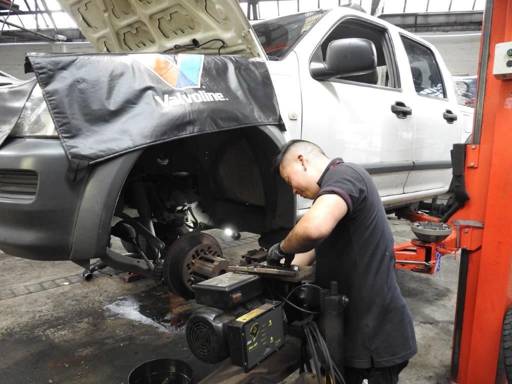 A Man is Working on a Wheel of a Car — Wollongong Auto Excellence In Wollongong, NSW