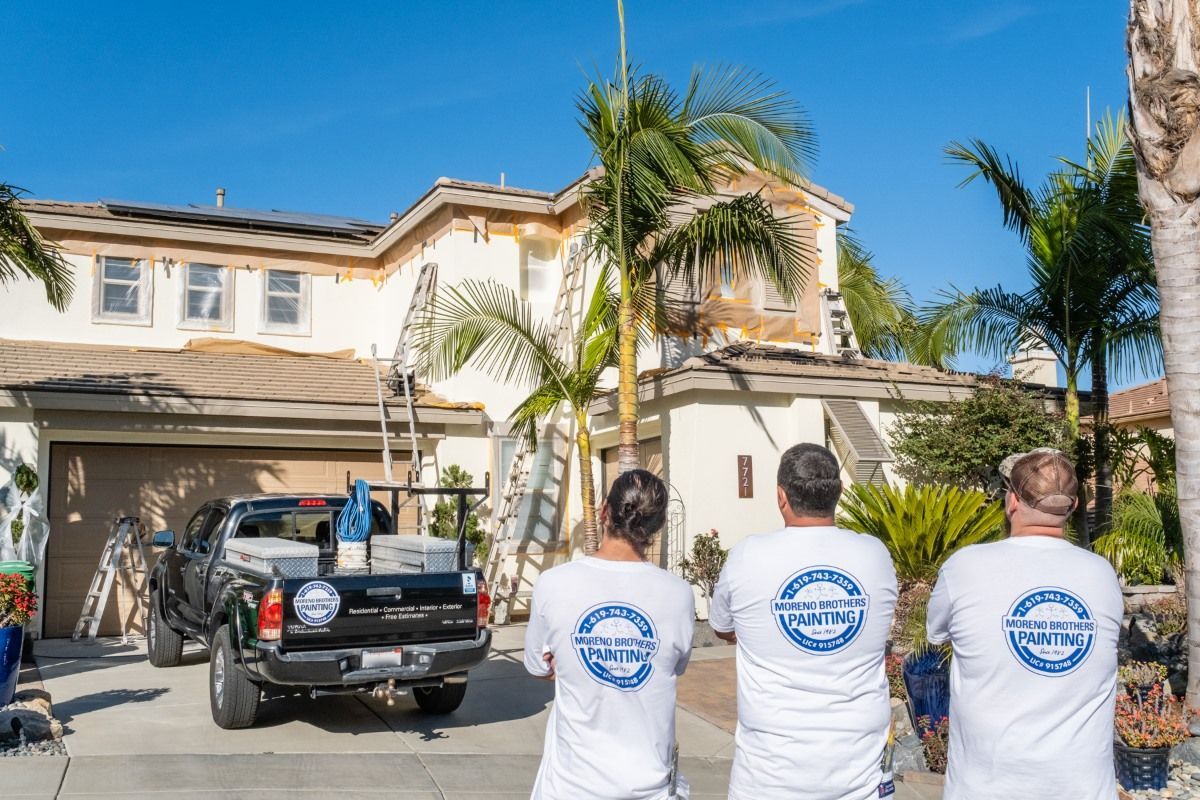 A group of men are standing in front of a house.