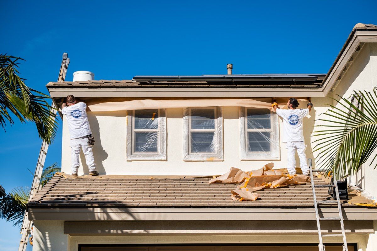 Two men are working on the roof of a house.