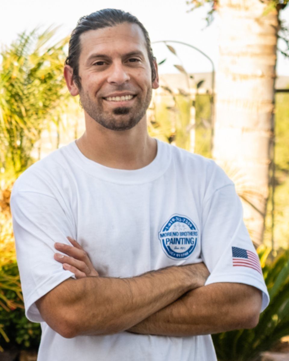 A man wearing a white shirt that says painting on it
