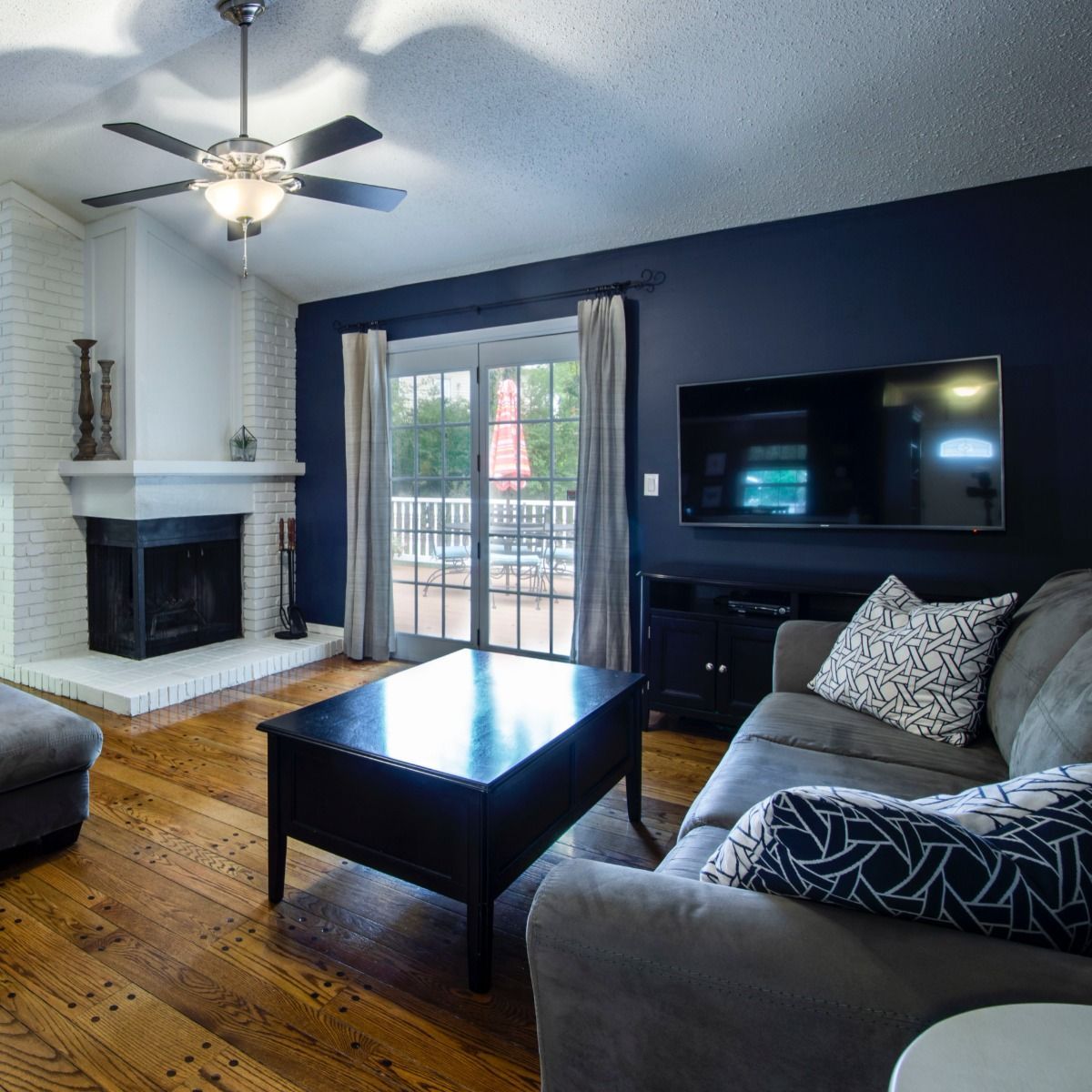 A living room with a fireplace and a flat screen tv
