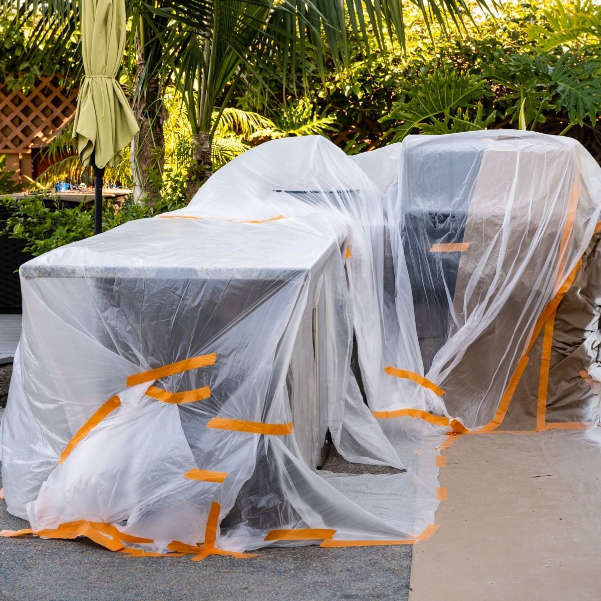 A table and chairs are wrapped in plastic