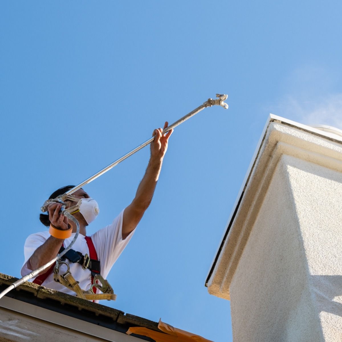 A man is spraying a building with a hose