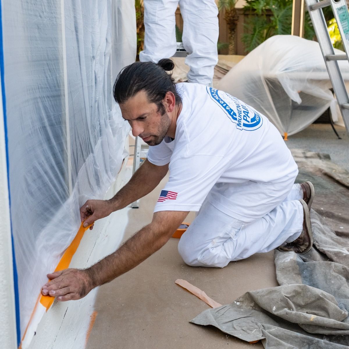A man in a white shirt with the word painting on the back