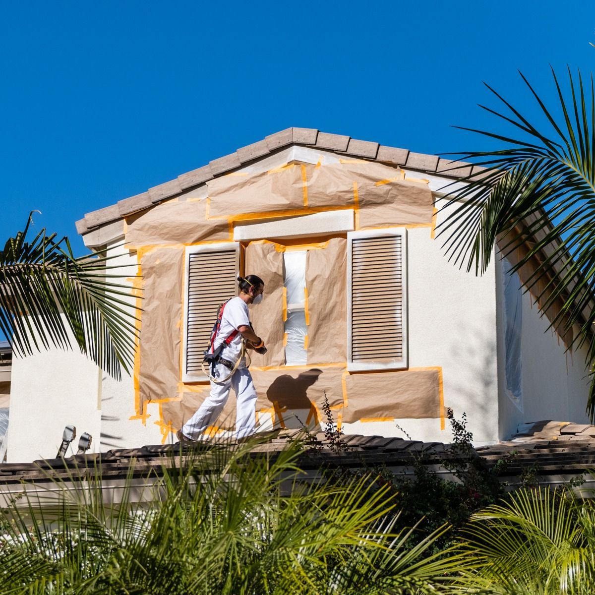 A man is painting the side of a house.
