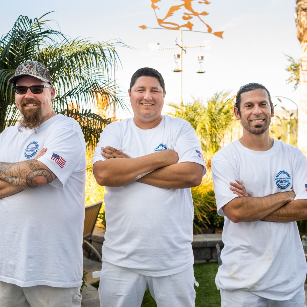 Three men are posing for a picture with their arms crossed