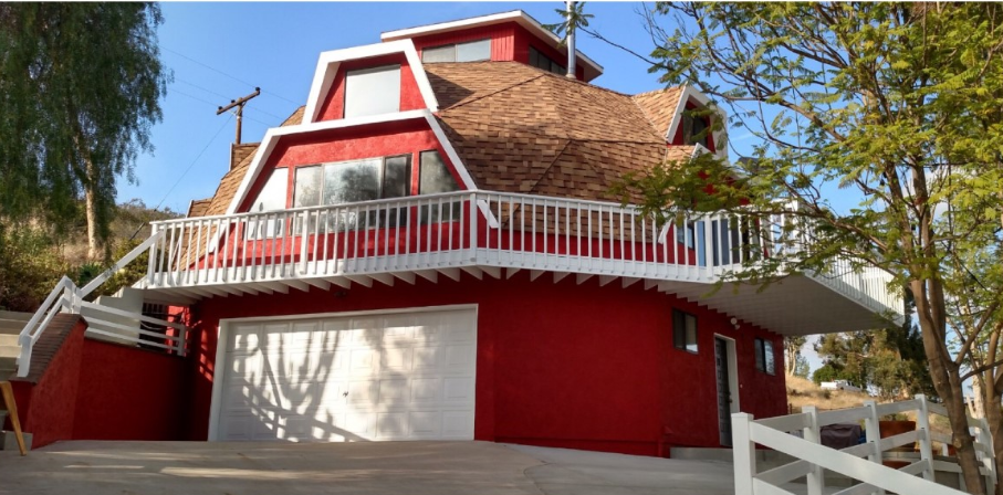 A red and white house with a balcony and stairs