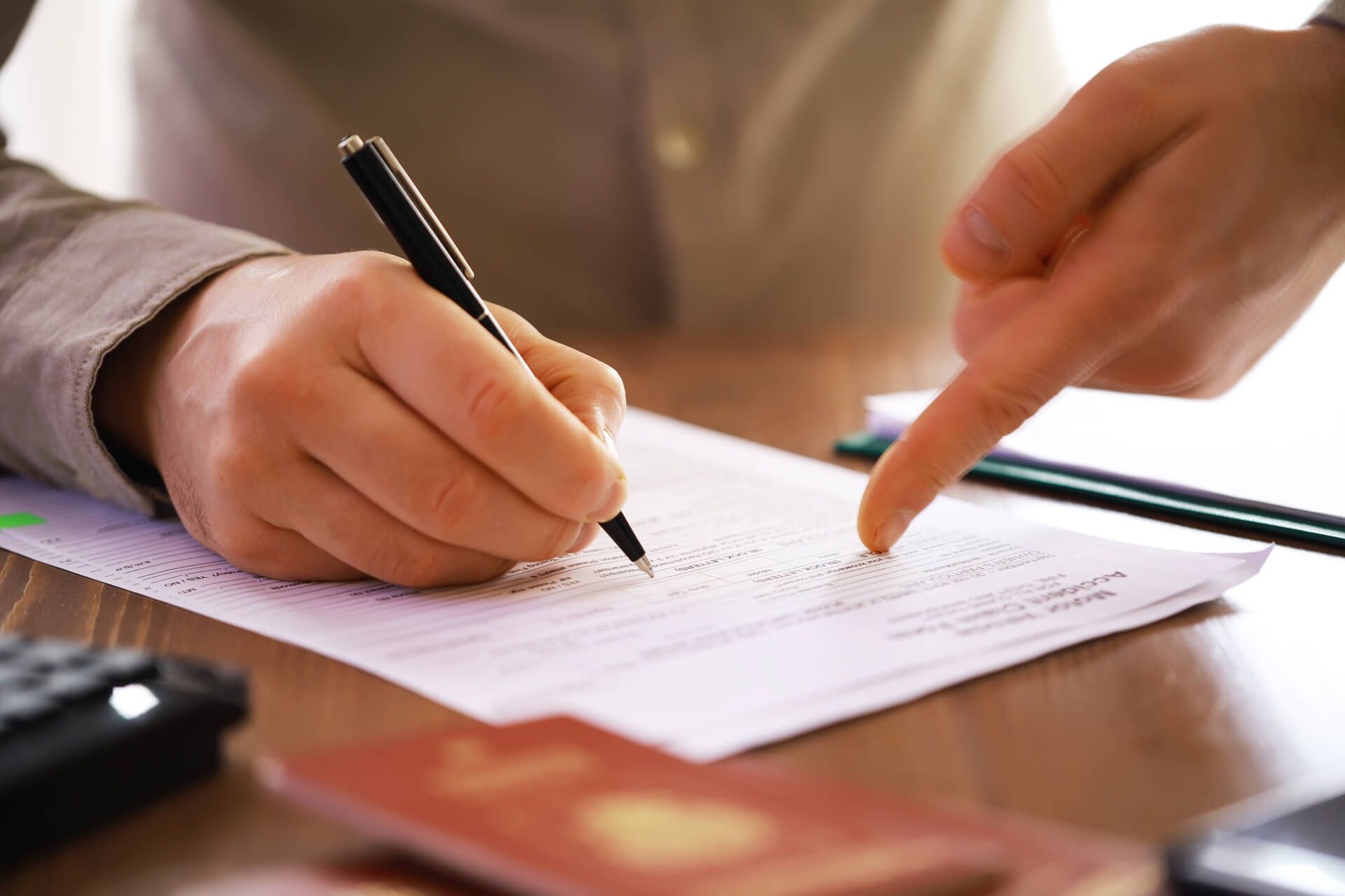 A person is writing on a piece of paper and pointing at it