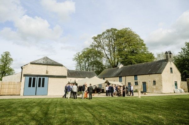 Rear elevation of juniper house, with people from a wedding party outside