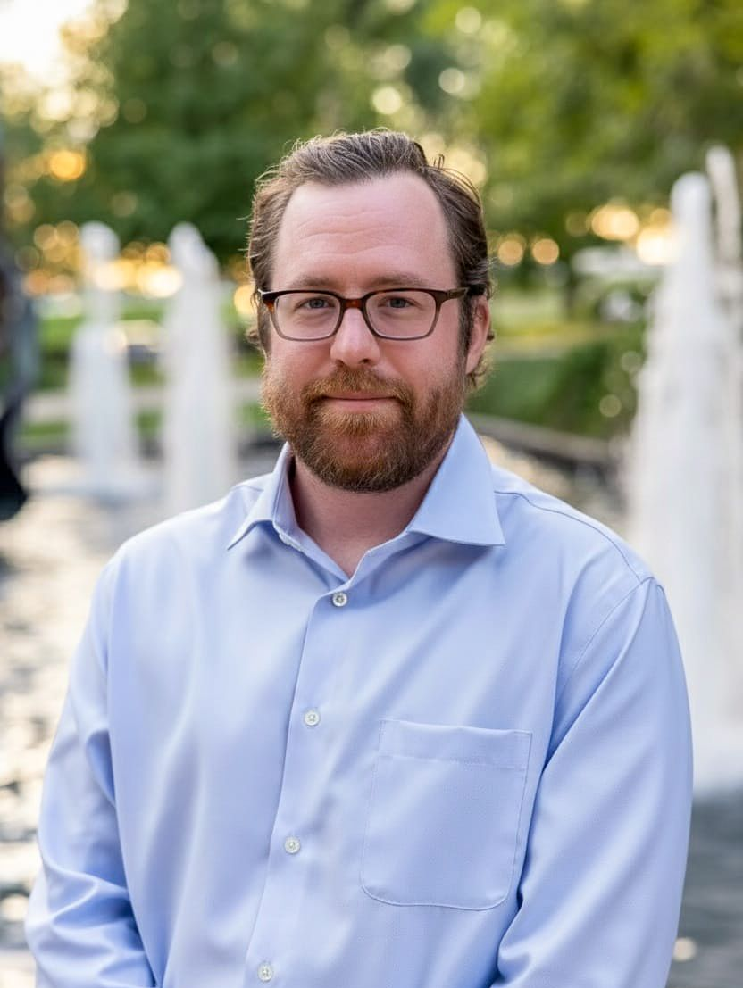 A man in a suit and tie is smiling for the camera.