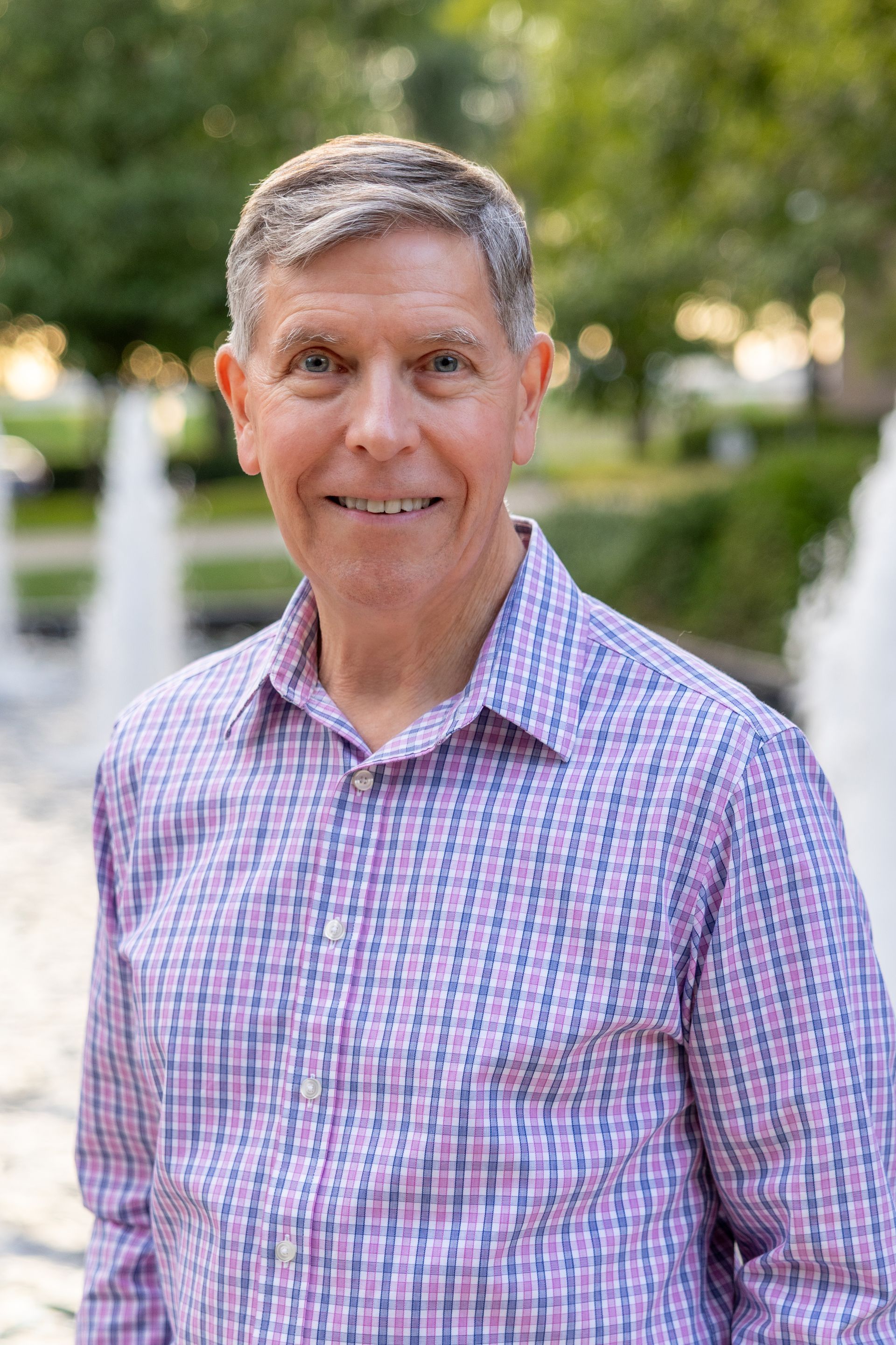 A man in a suit and tie is smiling for the camera.