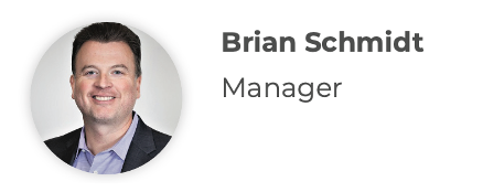 Brian Schmidt, Manager. Man with a smile, wearing a suit jacket and blue shirt.
