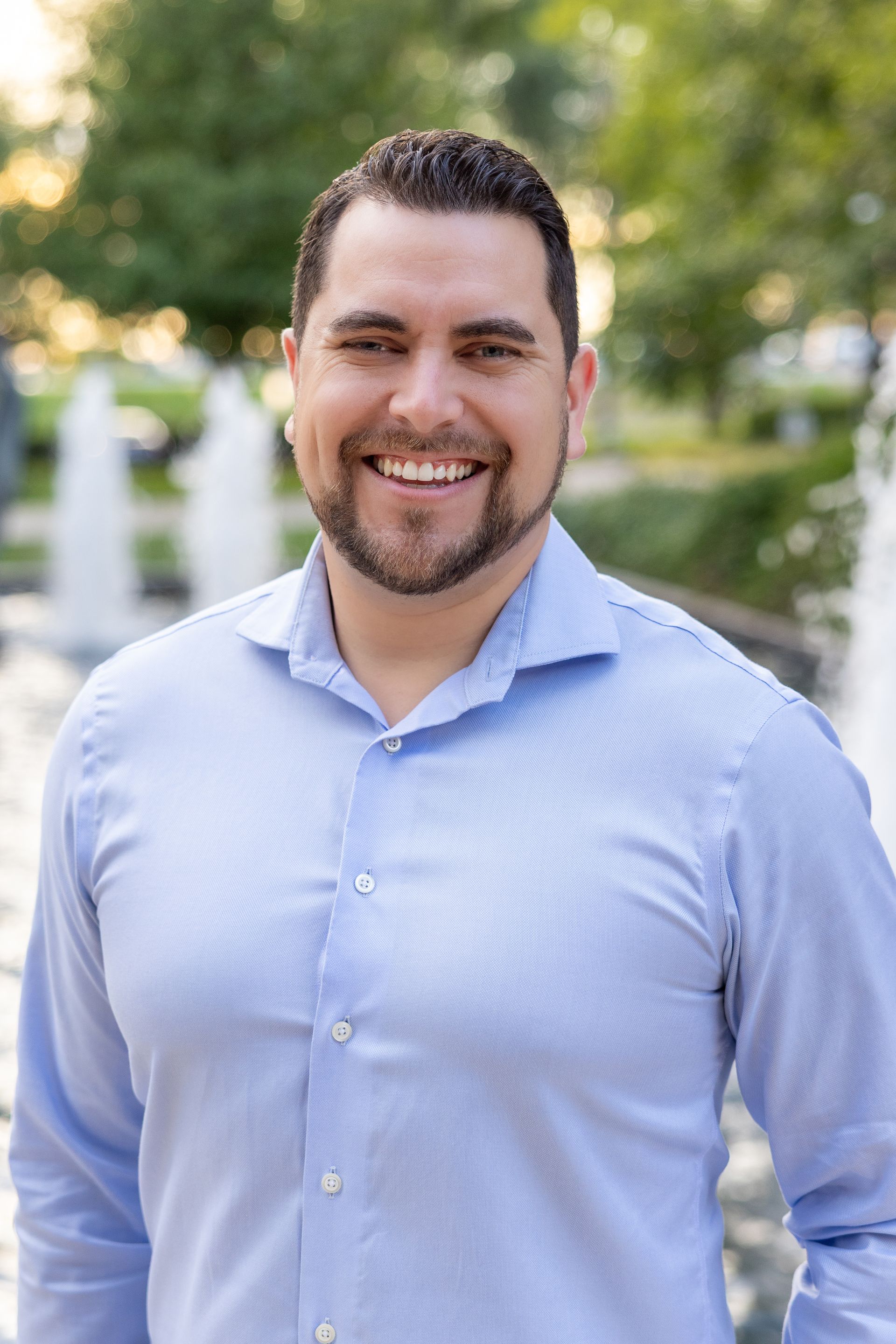 A man in a suit and tie is smiling for the camera.