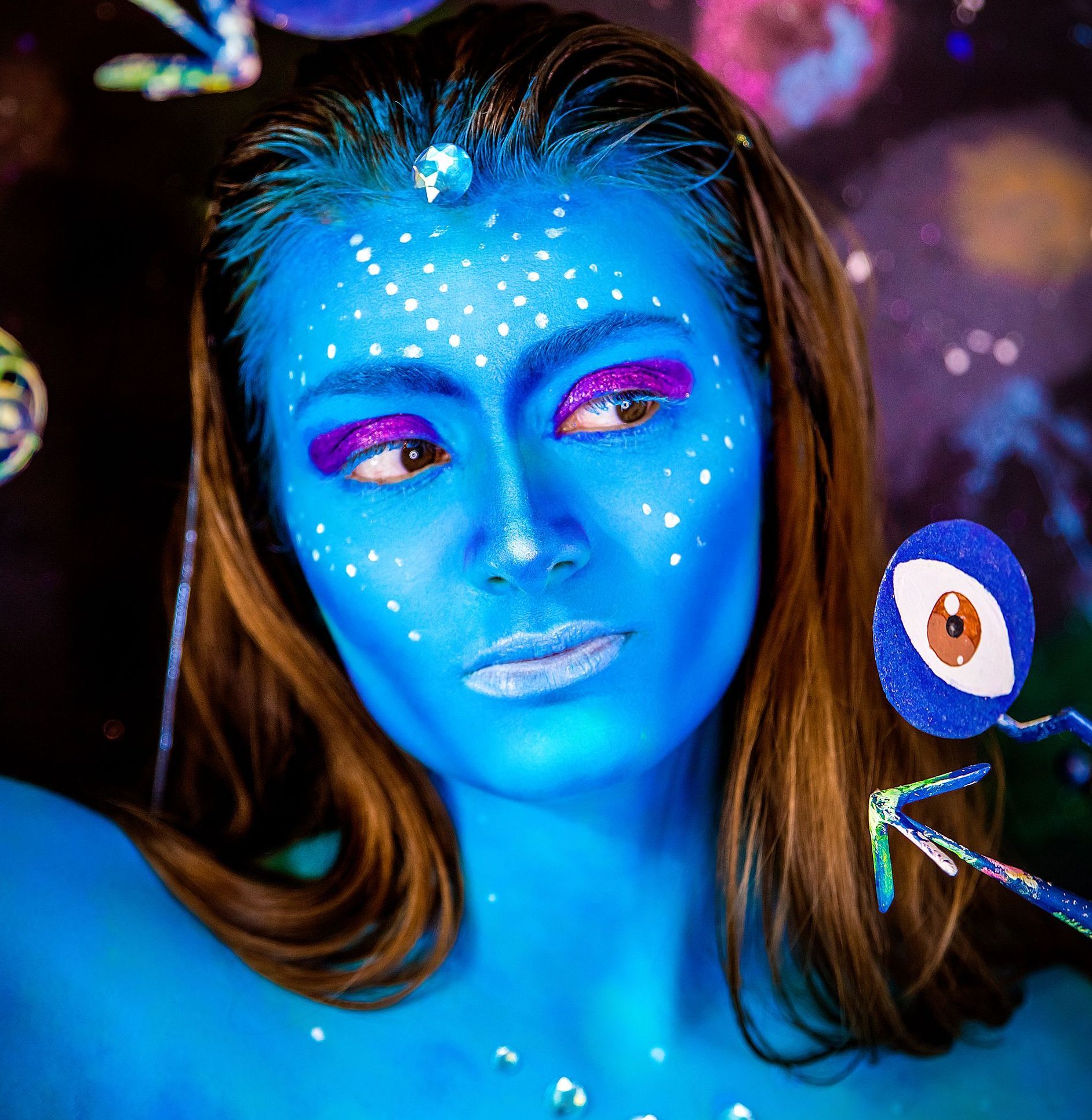 picture of woman with face painted like character from Avatar movie