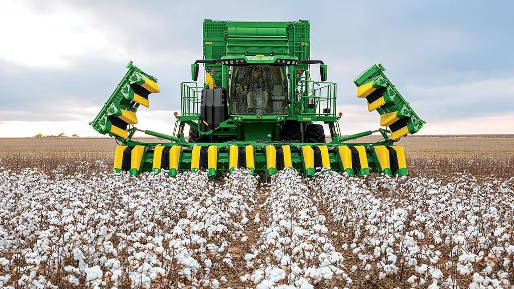 A John Deere cotton picker in a cotton field