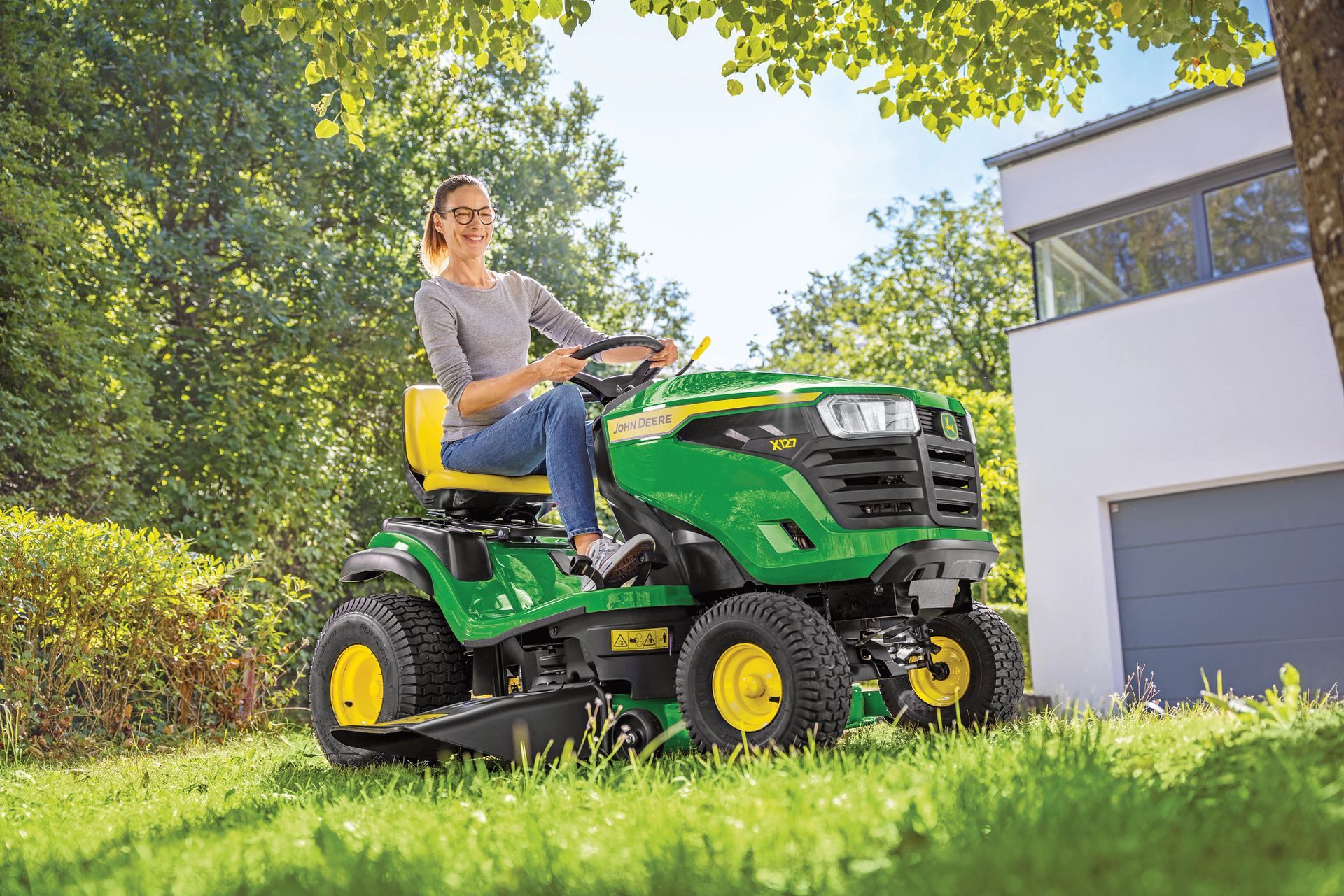 A green and yellow John Deere tractor is parked in a field.