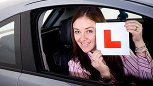 A lady holding a L sign
