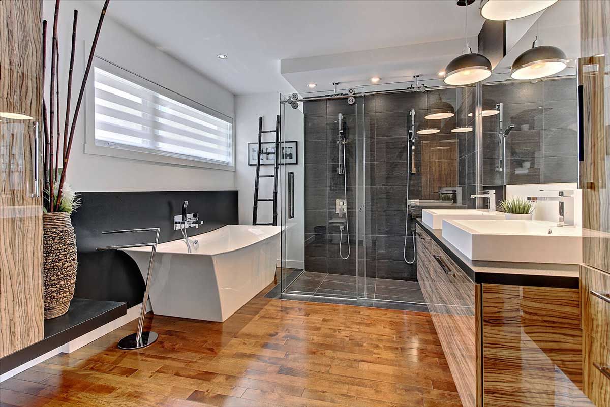 Salle de bains moderne avec baignoire îlot, douche en verre et meuble-lavabo en bois.