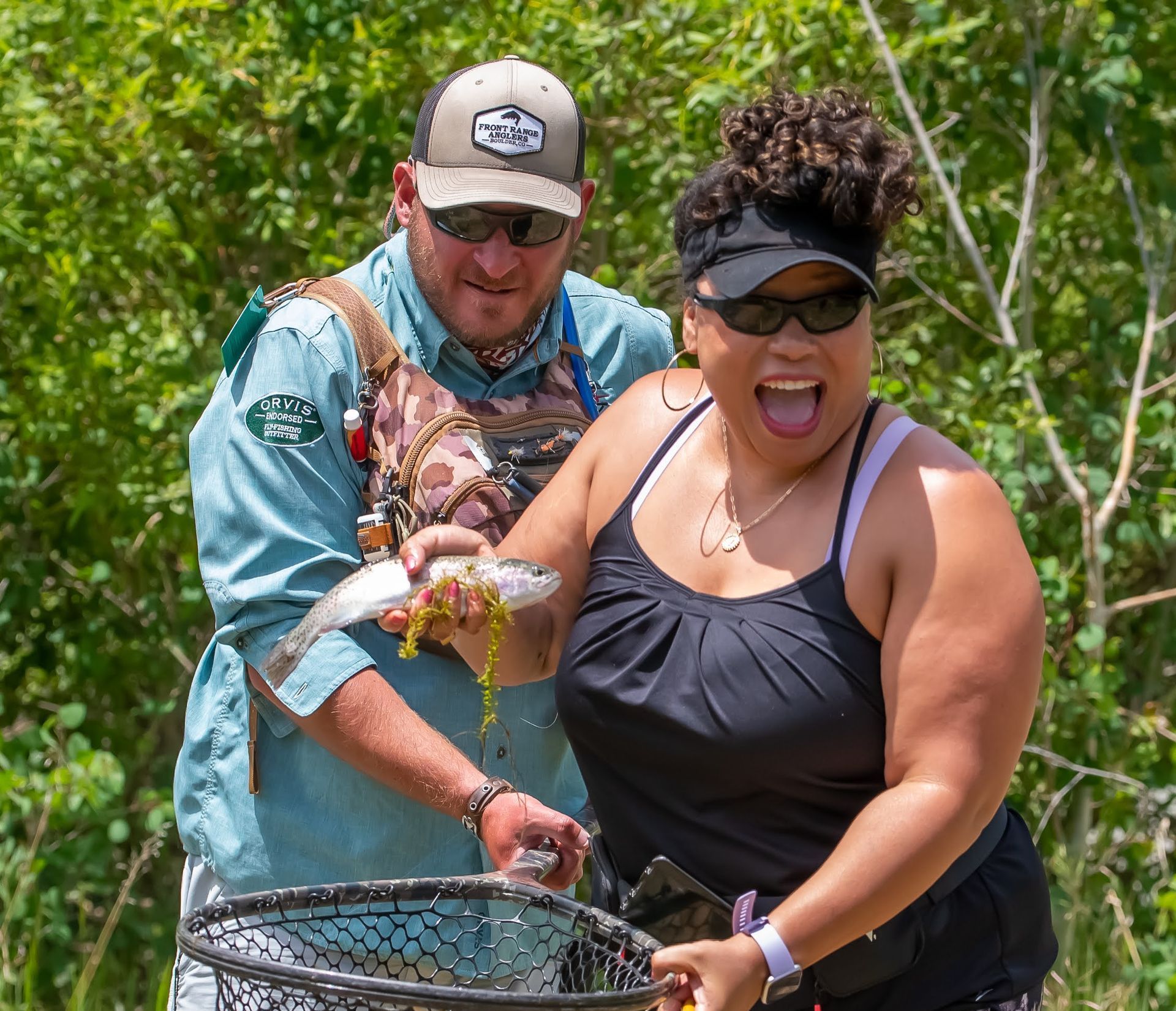 A man and a woman are holding a fish in a net.
