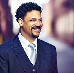 A man in a suit and tie is smiling.