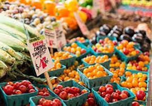 A variety of fruits and vegetables are for sale at a farmers market.