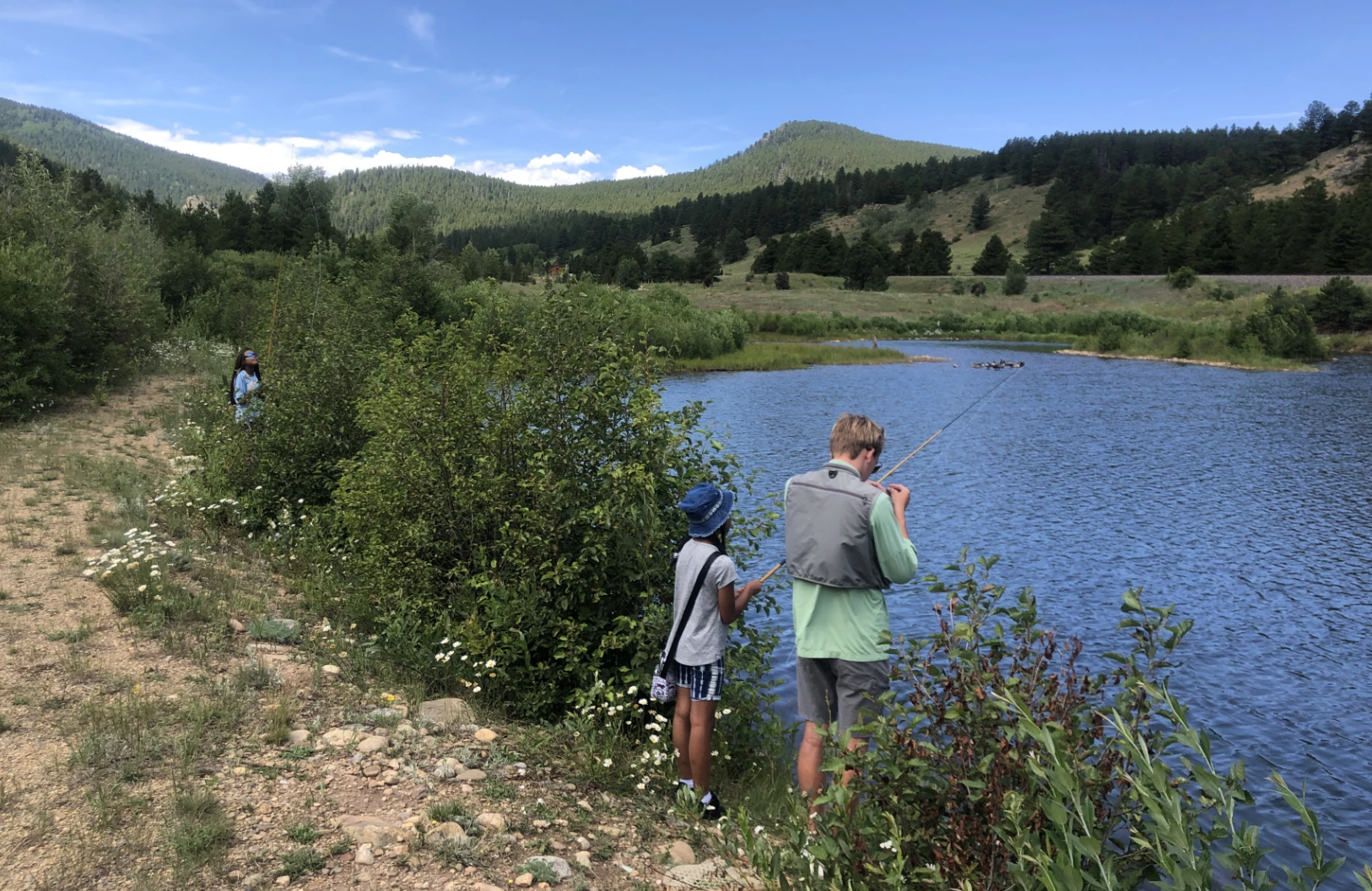 A man and a boy are fishing in a lake.