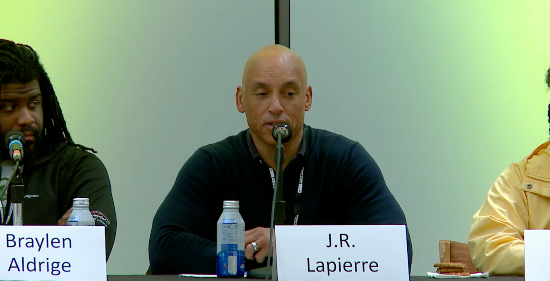 A man sitting at a table with a name tag that says j.r. lapierre