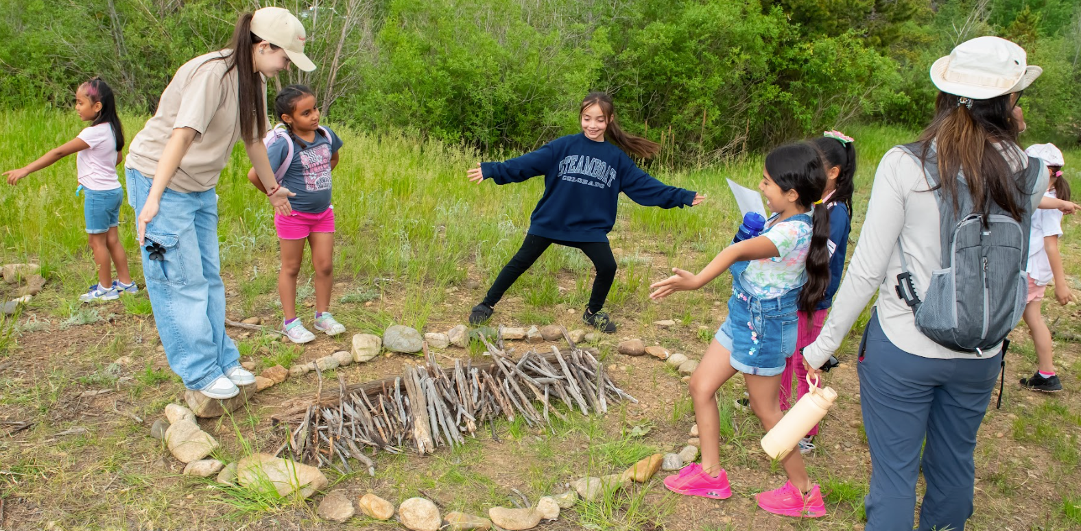 A group of children are playing in a circle made of rocks.