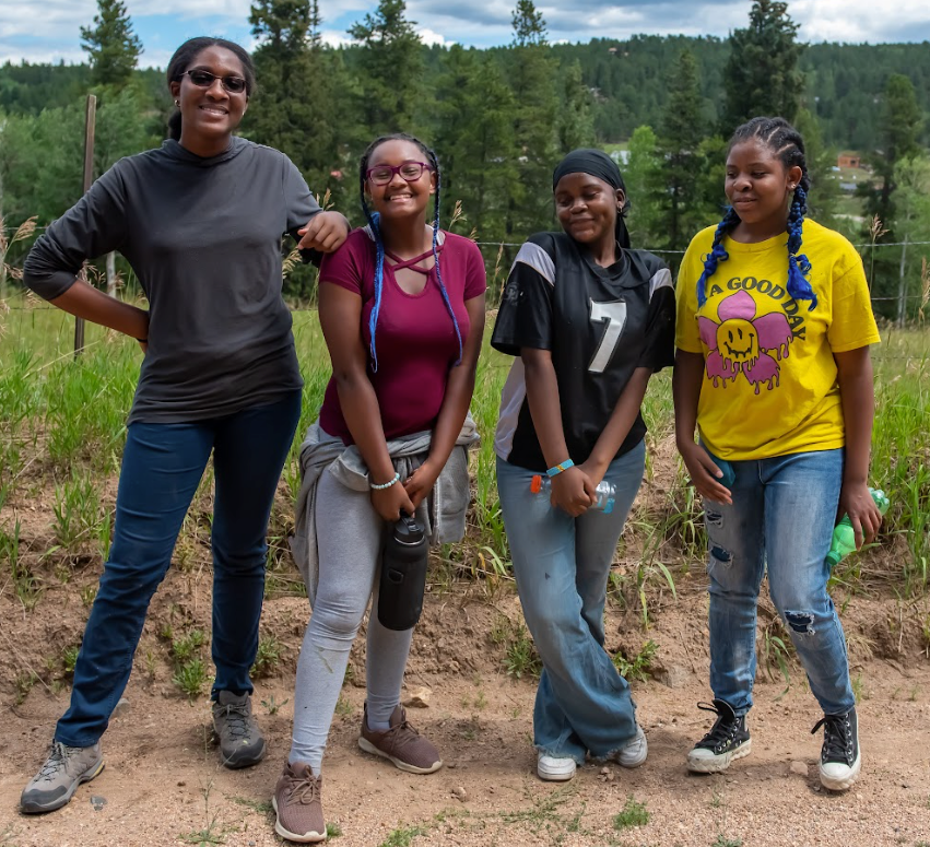 A group of young women are posing for a picture in a field