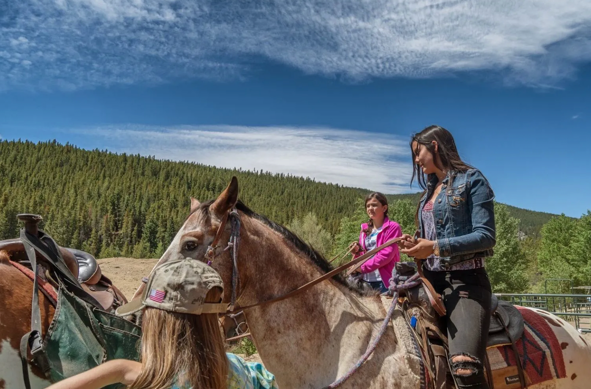Two women are riding horses in the woods.