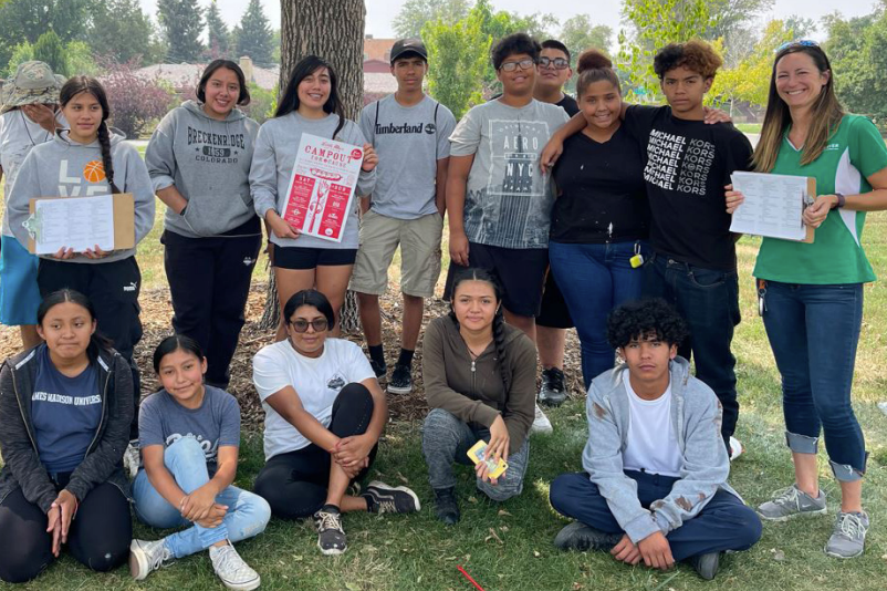 A group of people are posing for a picture in a park.