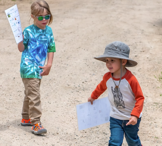 A boy and a girl are walking down a dirt road