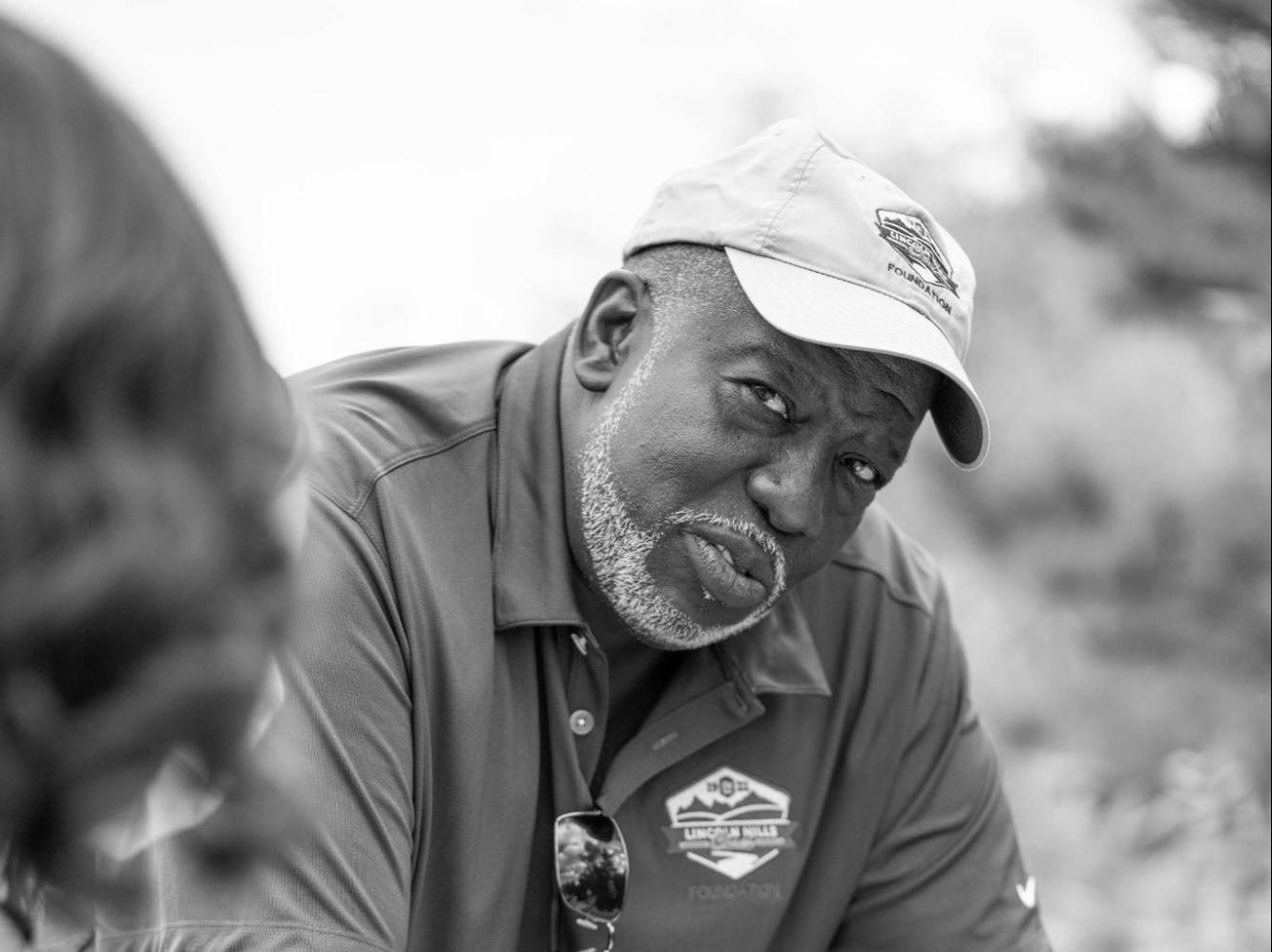 A black and white photo of a man wearing a hat