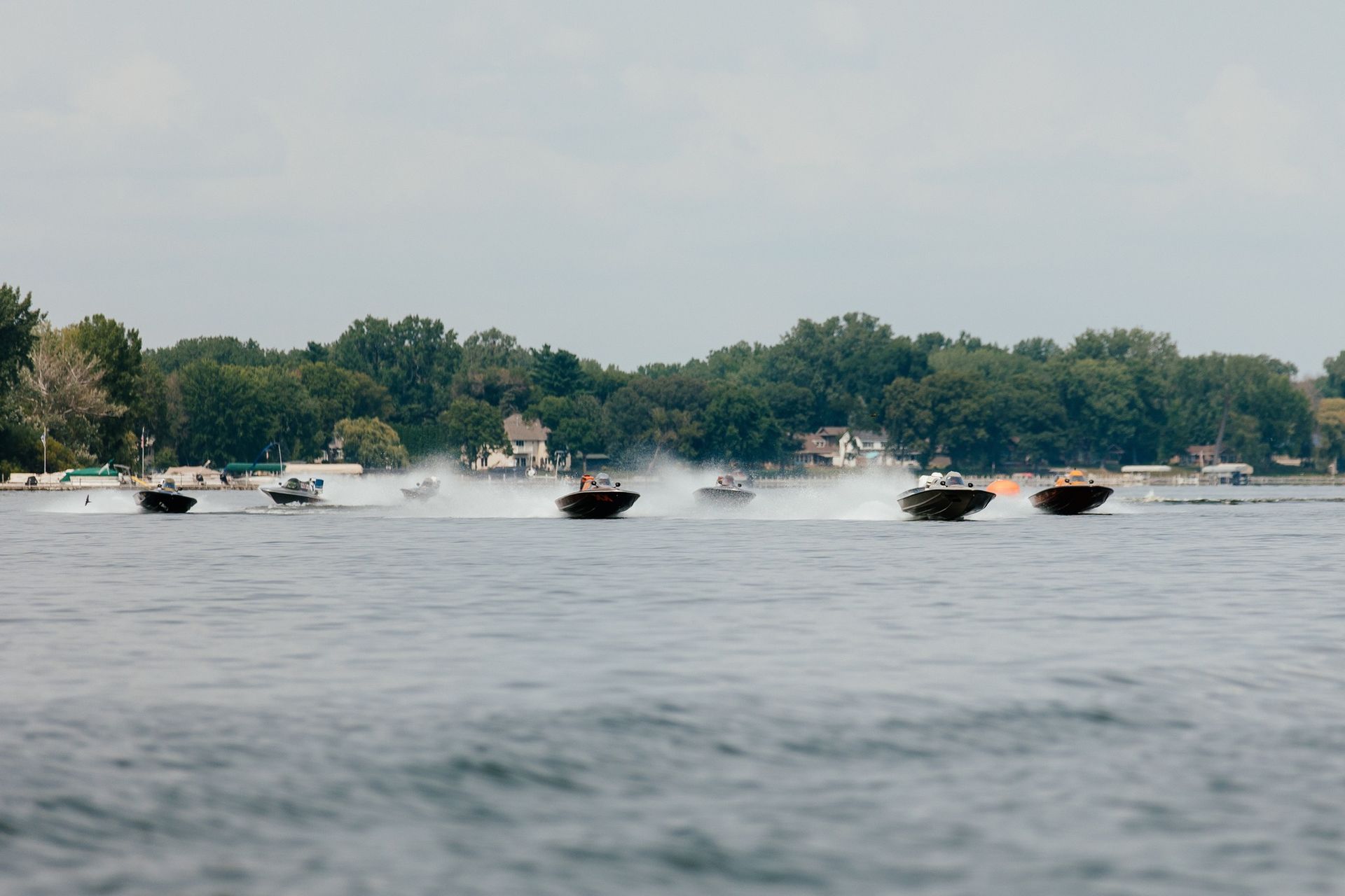 A group of boats are racing on a lake.