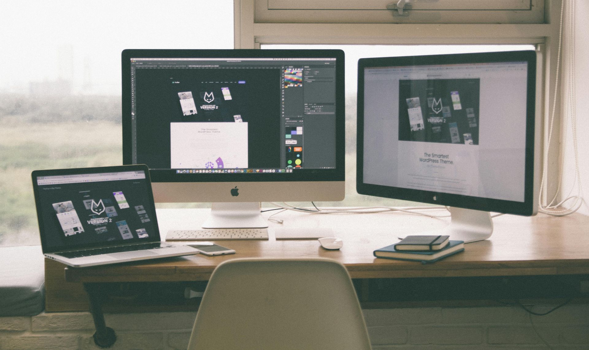 Workspace with three computer screens displaying design layouts — Twiss Digital Marketing in Caldwell, ID