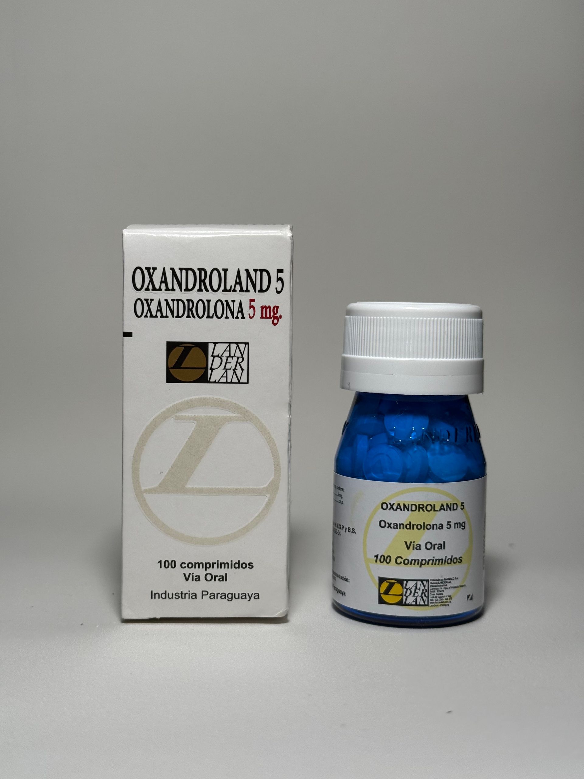 Caja y frasco de comprimidos de Oxandroland 5 mg; caja blanca con texto, frasco azul, tapa blanca.