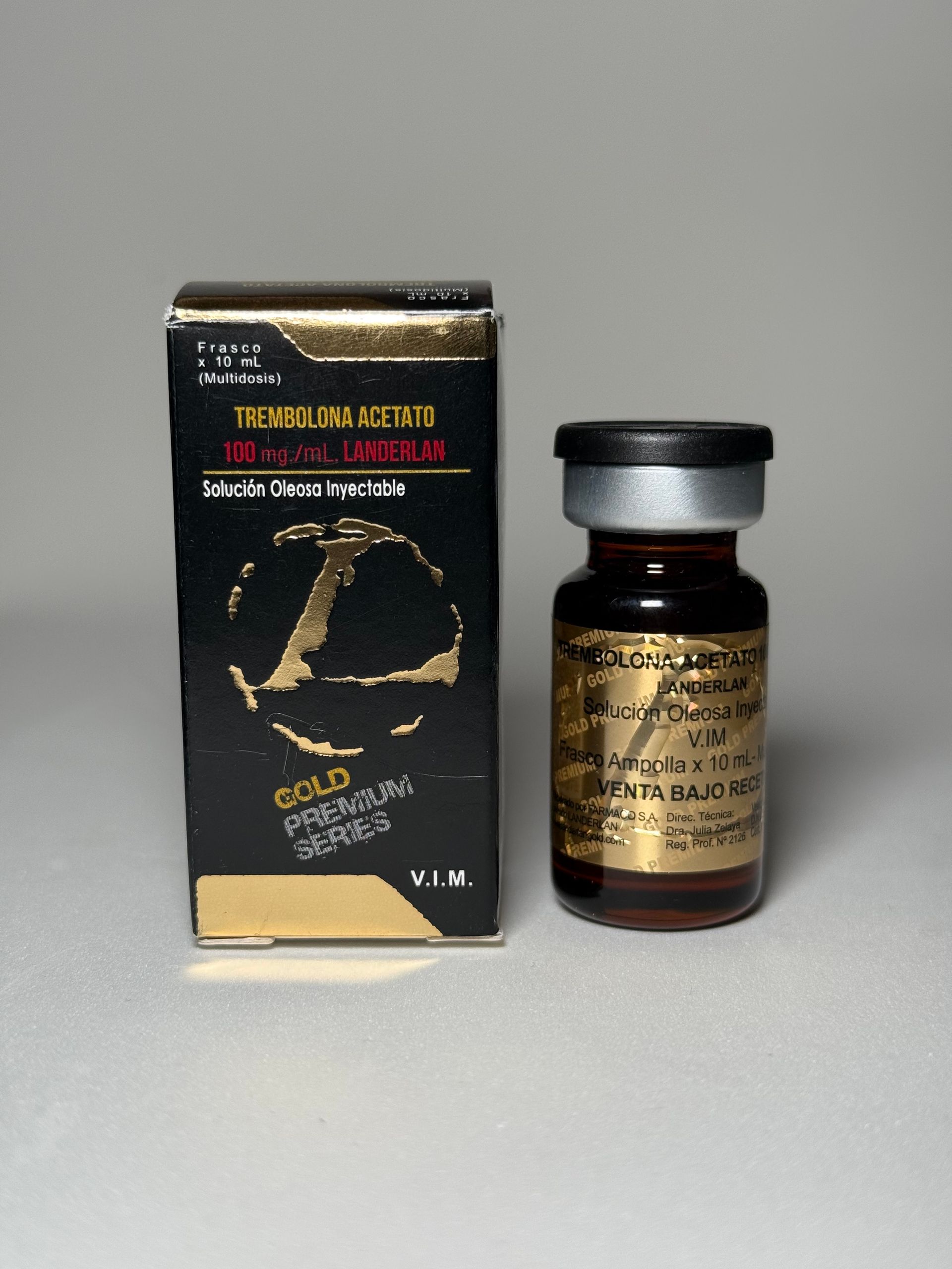 Caja negra y dorada y vial con líquido, posiblemente medicamento. Letras doradas.