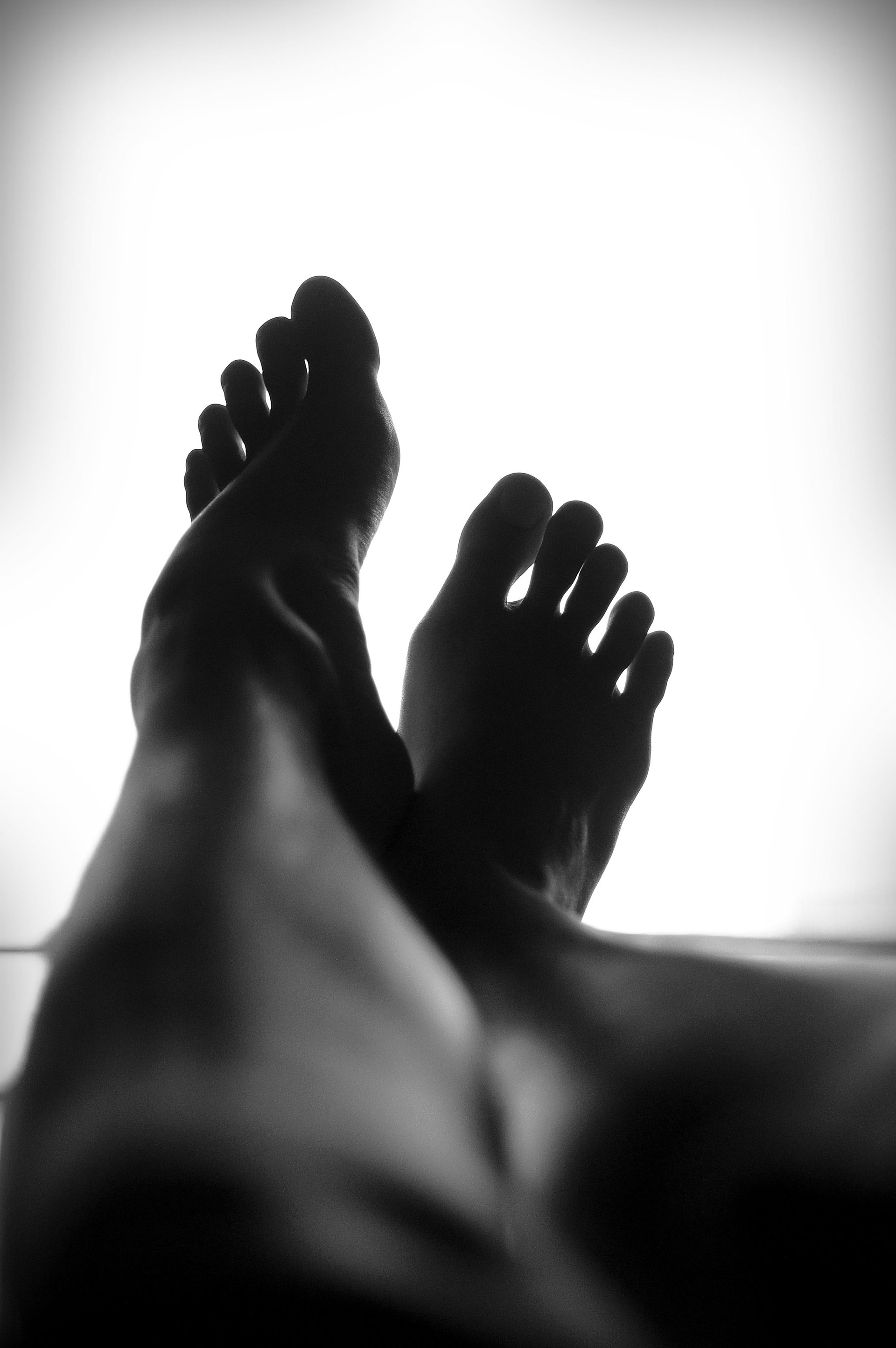 Een zwart-witfoto van de voeten van een persoon