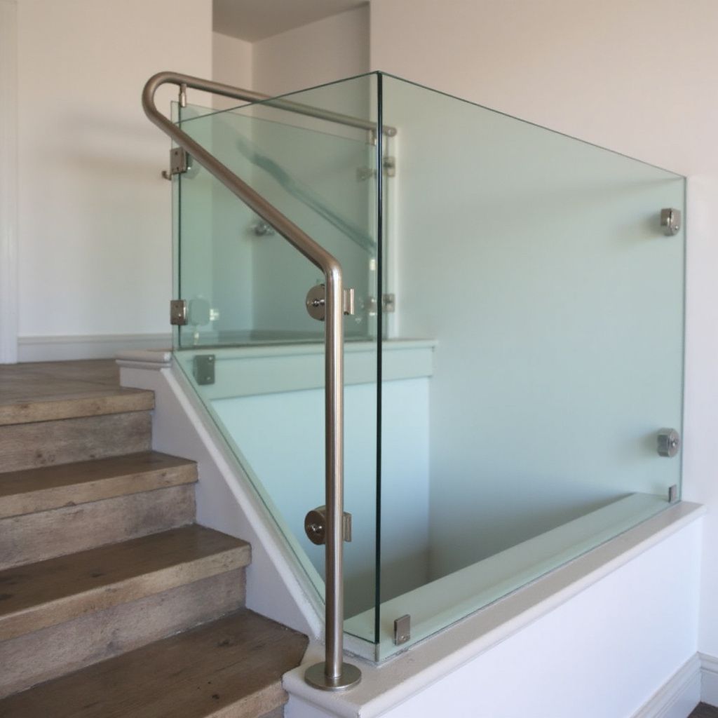 Staircase with glass panels and stainless steel railing for safety, modern design.
